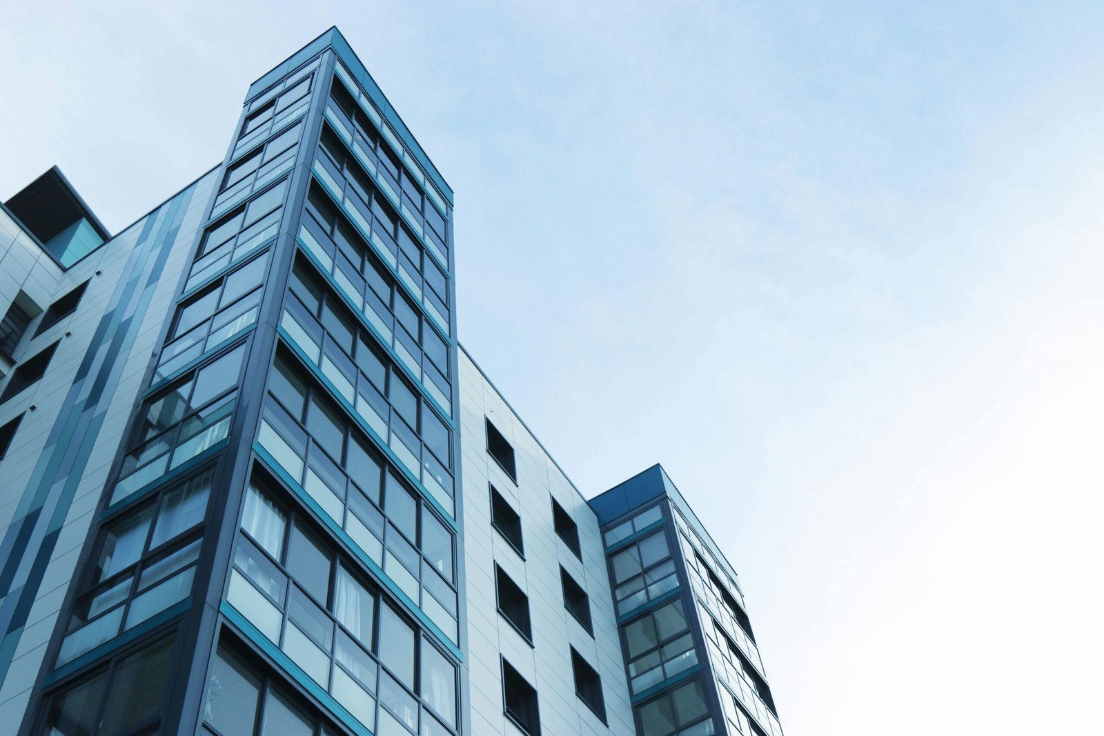 Modern commercial tower viewed from below against a clear sky